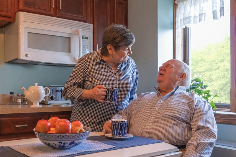 Senior couple have coffee togther in their kitchen
