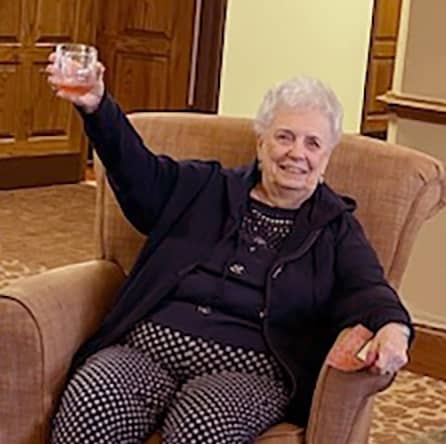 Elderly woman raises her glass