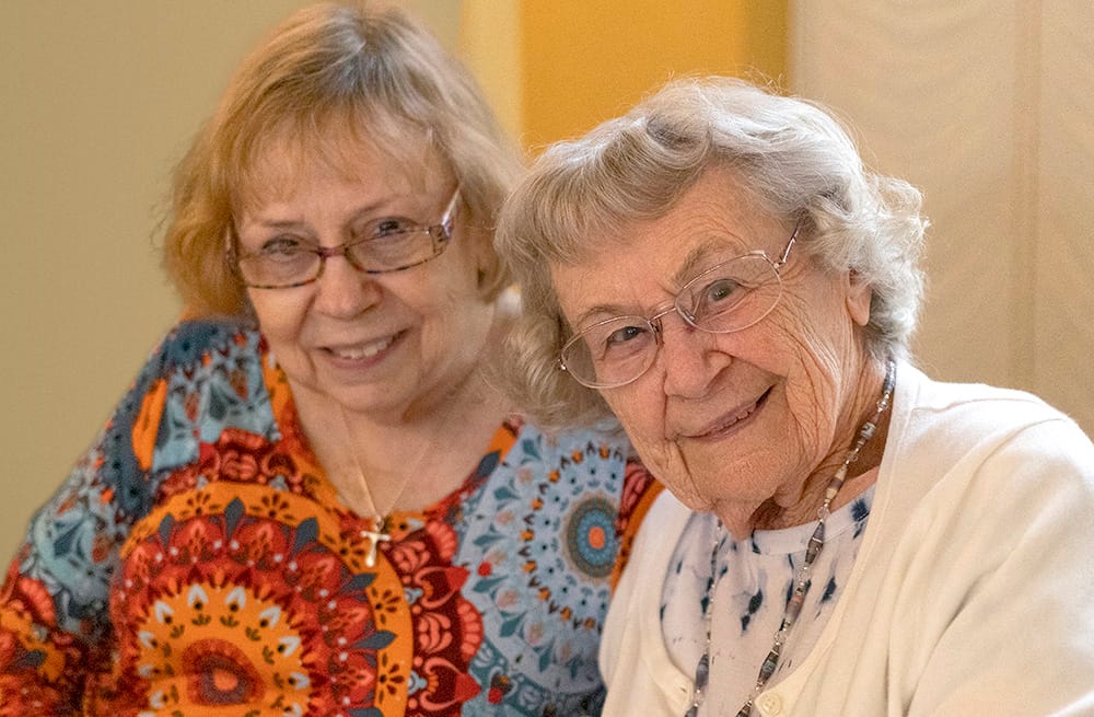 Two elderly women smiling together